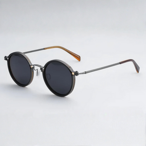 Round sunglasses with dark lenses and metallic frame on a light gray background