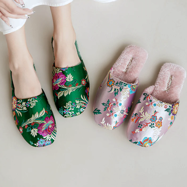 Pair of floral-patterned slippers on a plain background