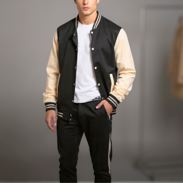 Person wearing a black and beige varsity jacket on a gray background
