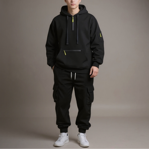 Person wearing a black hoodie and cargo pants with white sneakers on a plain background