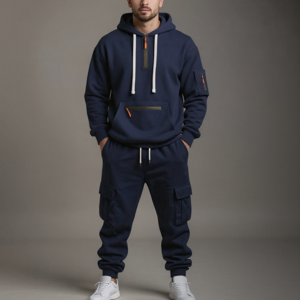 Person wearing a navy blue tracksuit with white accents on a gray background