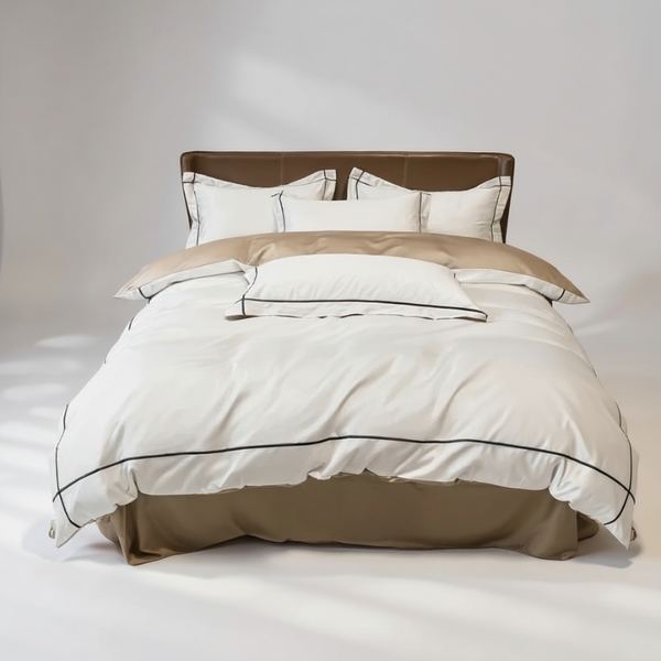 Beige and brown bed set with matching pillows on a neutral background