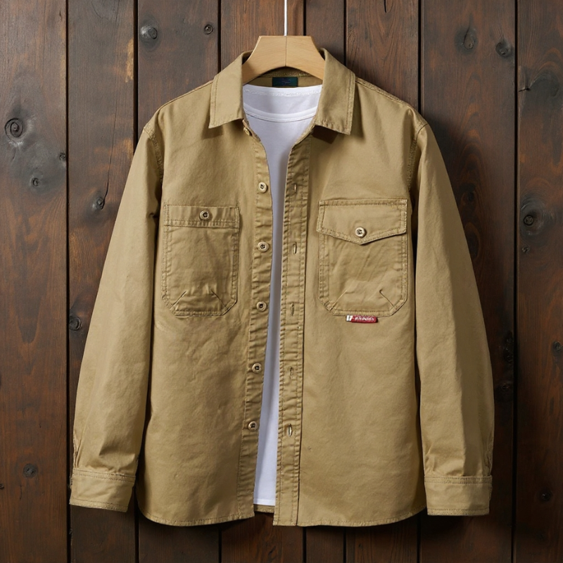 Man wearing a black shirt over a white shirt on a gray background