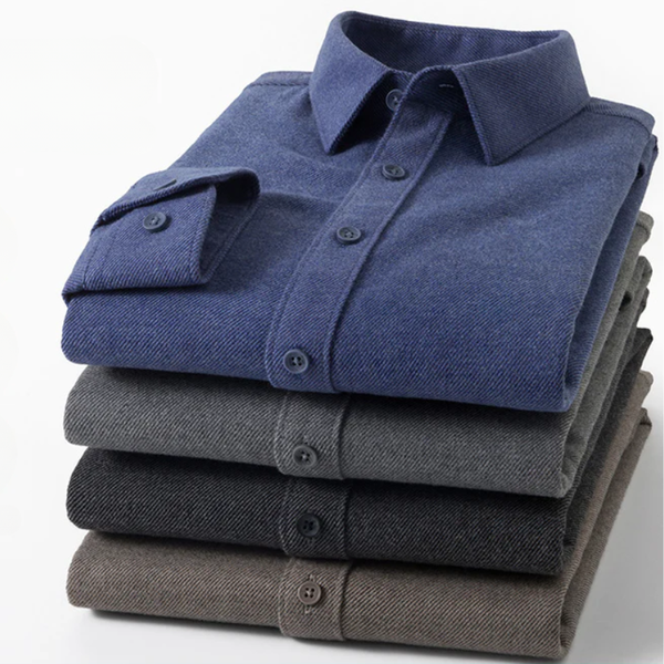Stack of folded blue, gray, and brown dress shirts on a white background
