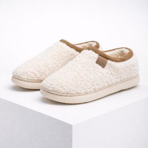 Pair of white slippers with brown accents on a light gray background