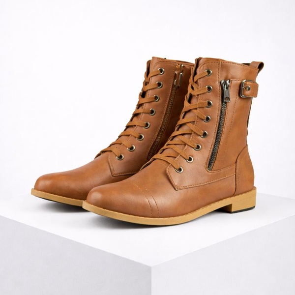 Pair of brown leather boots with zippers on a white background