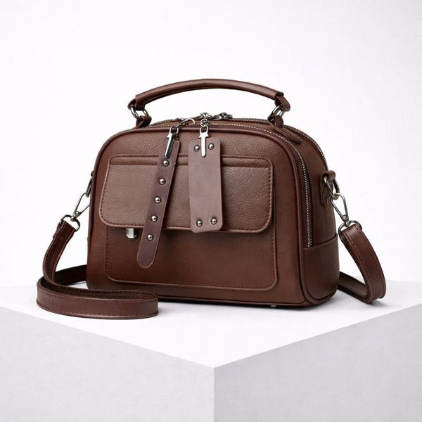 Brown leather handbag with silver accents on a white background