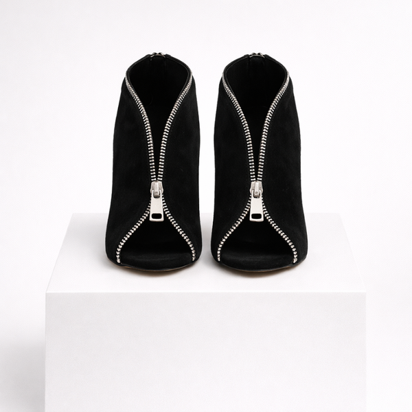 Black high-heeled shoes with zippers on a white background