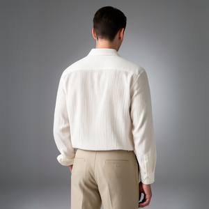 Man wearing a white shirt and beige pants against a gray background