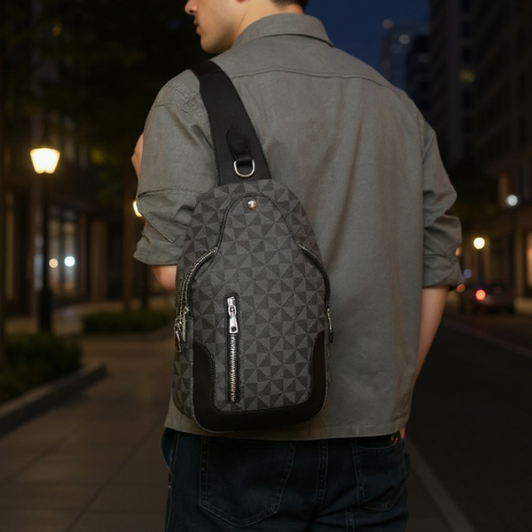 Person wearing a gray geometric-patterned backpack on a city street at night.