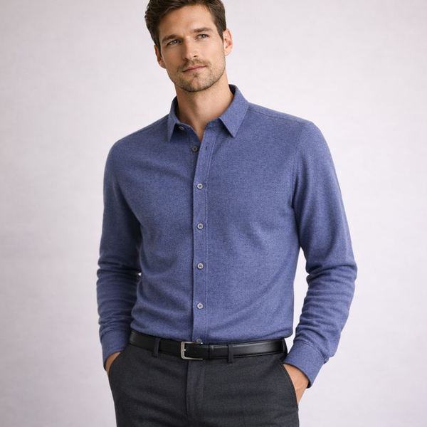 Man wearing a blue button-up shirt and black pants on a white background