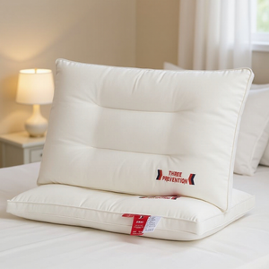 Two white pillows on a bed with a visible brand label in a bedroom setting.