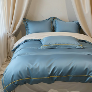 Blue bedspread with gold trim on a bed in a bedroom setting