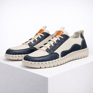 Pair of blue and white sneakers with orange accents on a white background