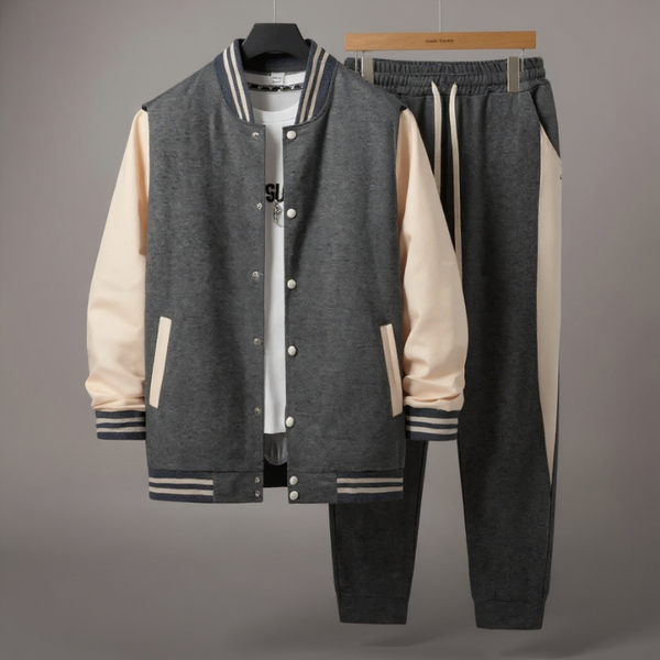 Gray varsity jacket with beige sleeves and black pants on a gray background