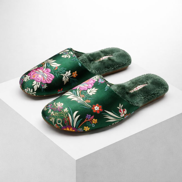 Green slippers with floral patterns on a white background