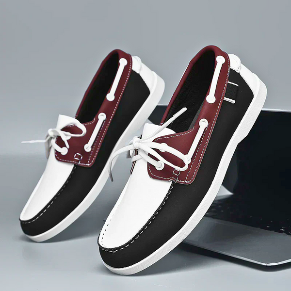 Black and maroon loafers with white laces on a gray background