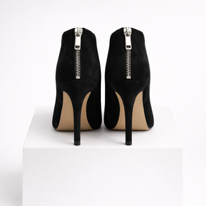 Black high-heeled shoes with zippers on a white background