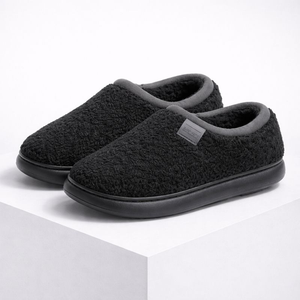 Pair of black slippers with gray interior on a white background