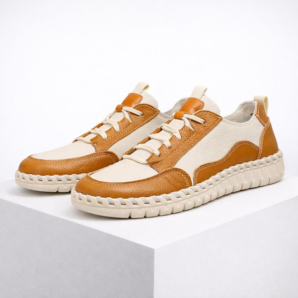Pair of brown and white sneakers on a white background