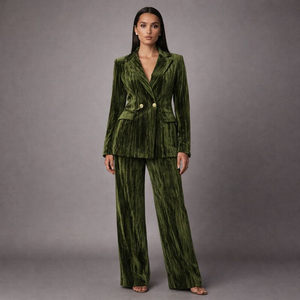 Woman wearing a green velvet suit against a gray background