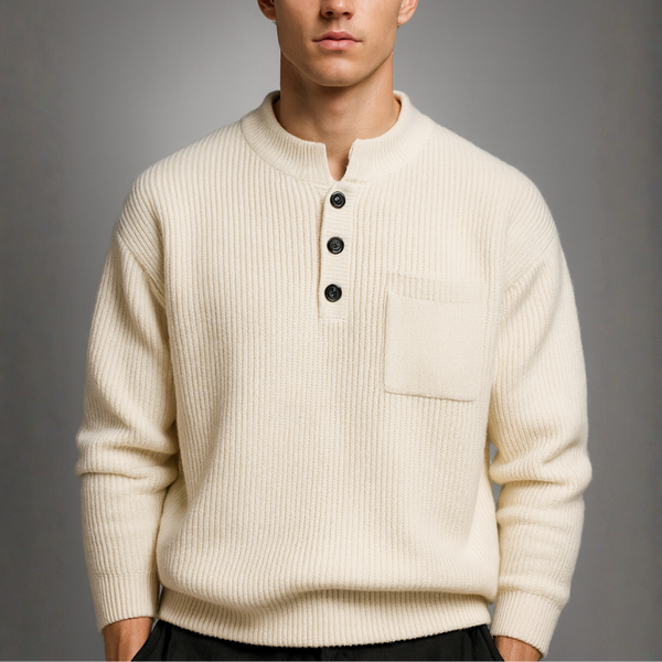 Man wearing a cream-colored sweater with black buttons against a gray background