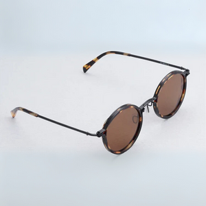 Sunglasses with tortoiseshell frame and brown lenses on a light blue background