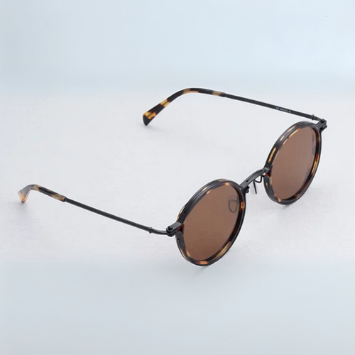 Sunglasses with tortoiseshell frame and brown lenses on a light blue background