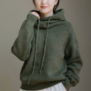 Person wearing a green hoodie against a neutral background