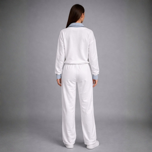 Person wearing a white tracksuit on a gray background