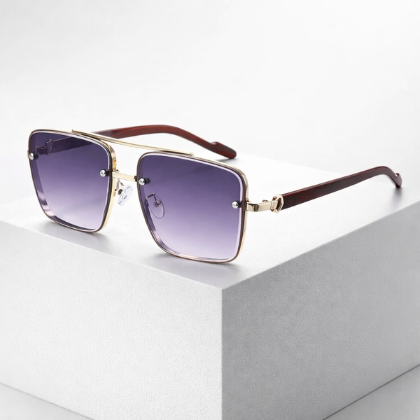 Sunglasses with gold frame and purple gradient lenses on a light gray surface