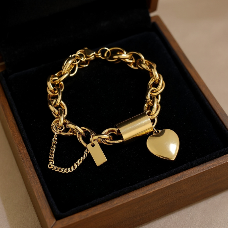 Silver chain bracelet with heart charm on a purple cushion in a box