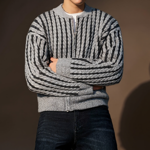 Person wearing a gray and black striped sweater against a brown background