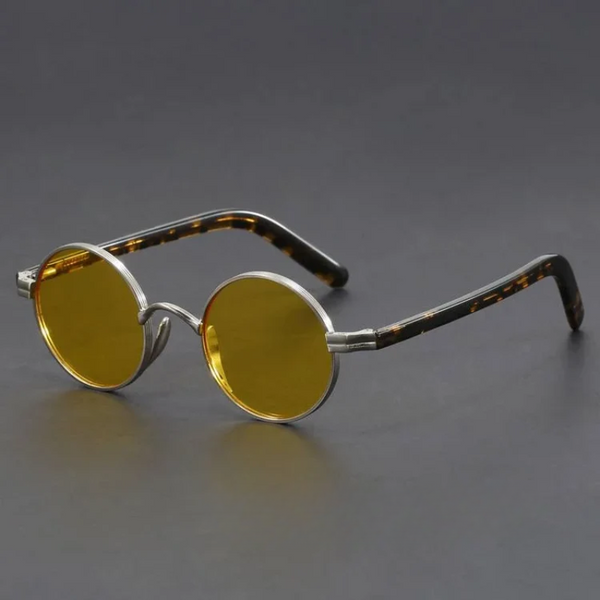 Round sunglasses with yellow lenses and tortoiseshell accents on a gray background