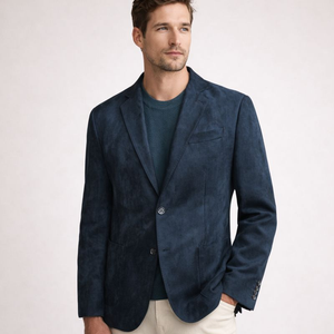 Man wearing a dark blue blazer over a green shirt on a white background