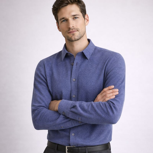 Man wearing a blue shirt with arms crossed on a light gray background