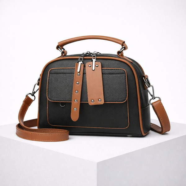 Black handbag with brown accents on a white background