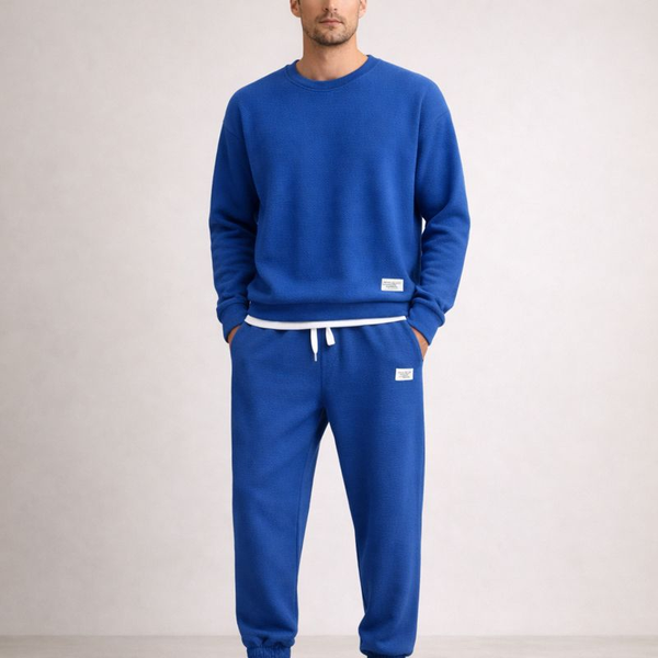 Person wearing a blue tracksuit on a plain background