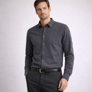 Man wearing a gray button-up shirt and dark pants on a light gray background