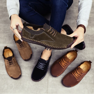 Person holding a brown leather shoe with other shoes on the ground.