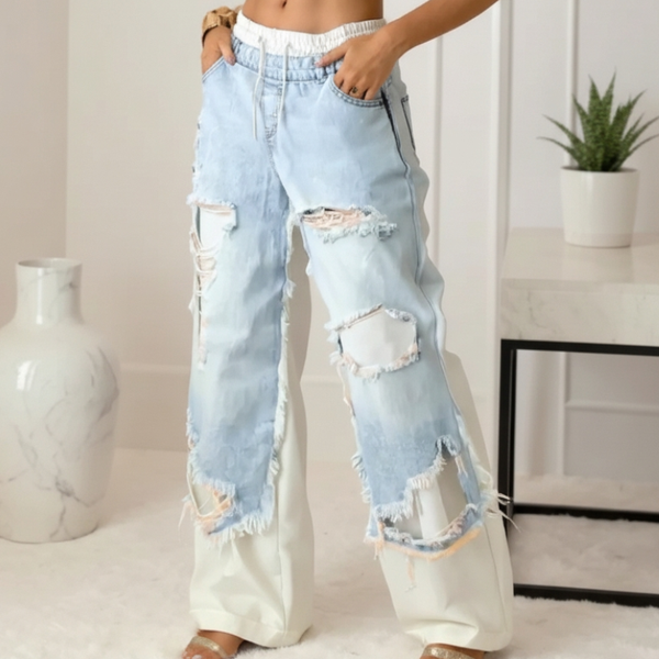 Light blue distressed jeans worn by a person indoors with a neutral background