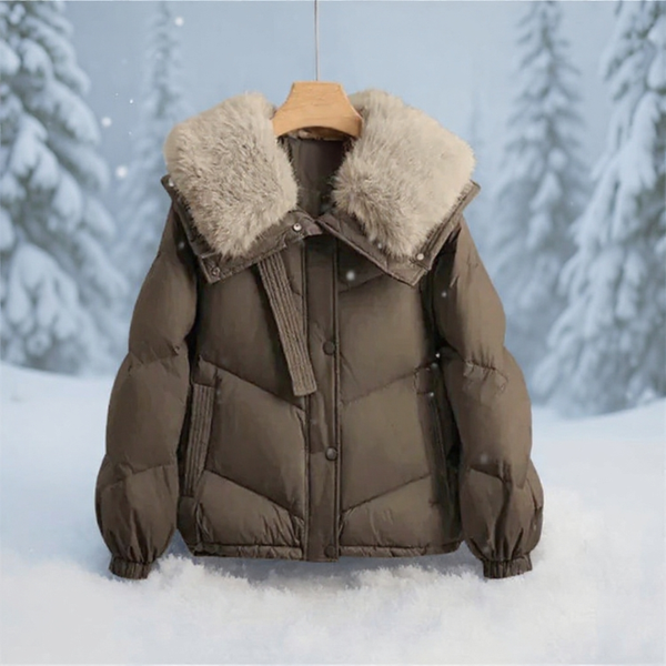 Brown puffer jacket with fur collar on a wooden hanger against a snowy background
