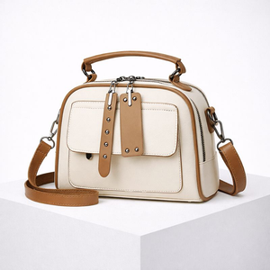 White handbag with brown accents on a white background