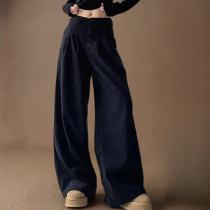 Person wearing black wide-leg pants on a brown background