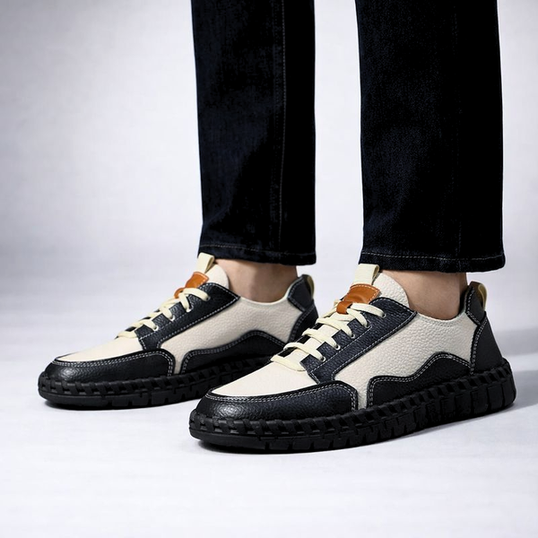 Black and white sneakers worn with dark jeans on a light gray background