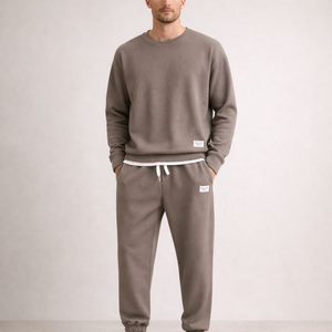 Man wearing a brown tracksuit against a plain background