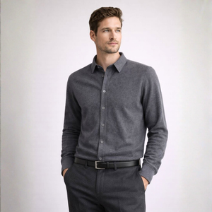 Man wearing a gray long-sleeve shirt and dark pants against a white background