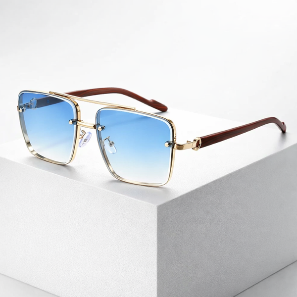 Sunglasses with gradient blue lenses and gold frame on a white surface