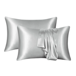 Two silver satin pillowcases on a white background