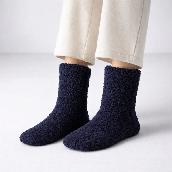 Navy blue textured socks worn with beige pants on a light gray background